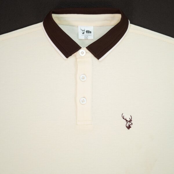 Beige polo shirt with brown collar and fils logo on a black background