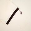 Close-up of a beige fabric with a black stripe and a fils logo emblem.