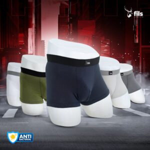 Men's underwear displayed on white cylindrical forms with a dark industrial background.