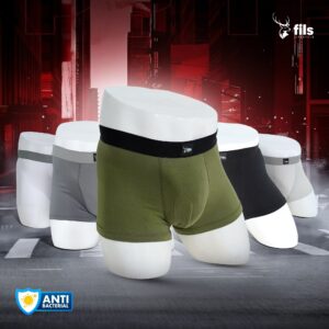 Three pairs of men's underwear in green, black, and gray on a futuristic cityscape background with 'fils' branding.