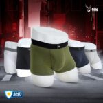 Set of men's underwear displayed on mannequin forms with a dark industrial background.