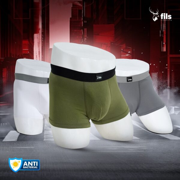 Three pairs of men's underwear in white, green, and gray on a dynamic background with 'fils' branding.